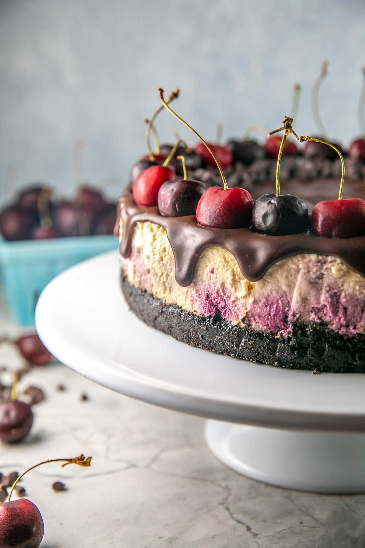 cherry cheesecake with oreo crust on a cake stand