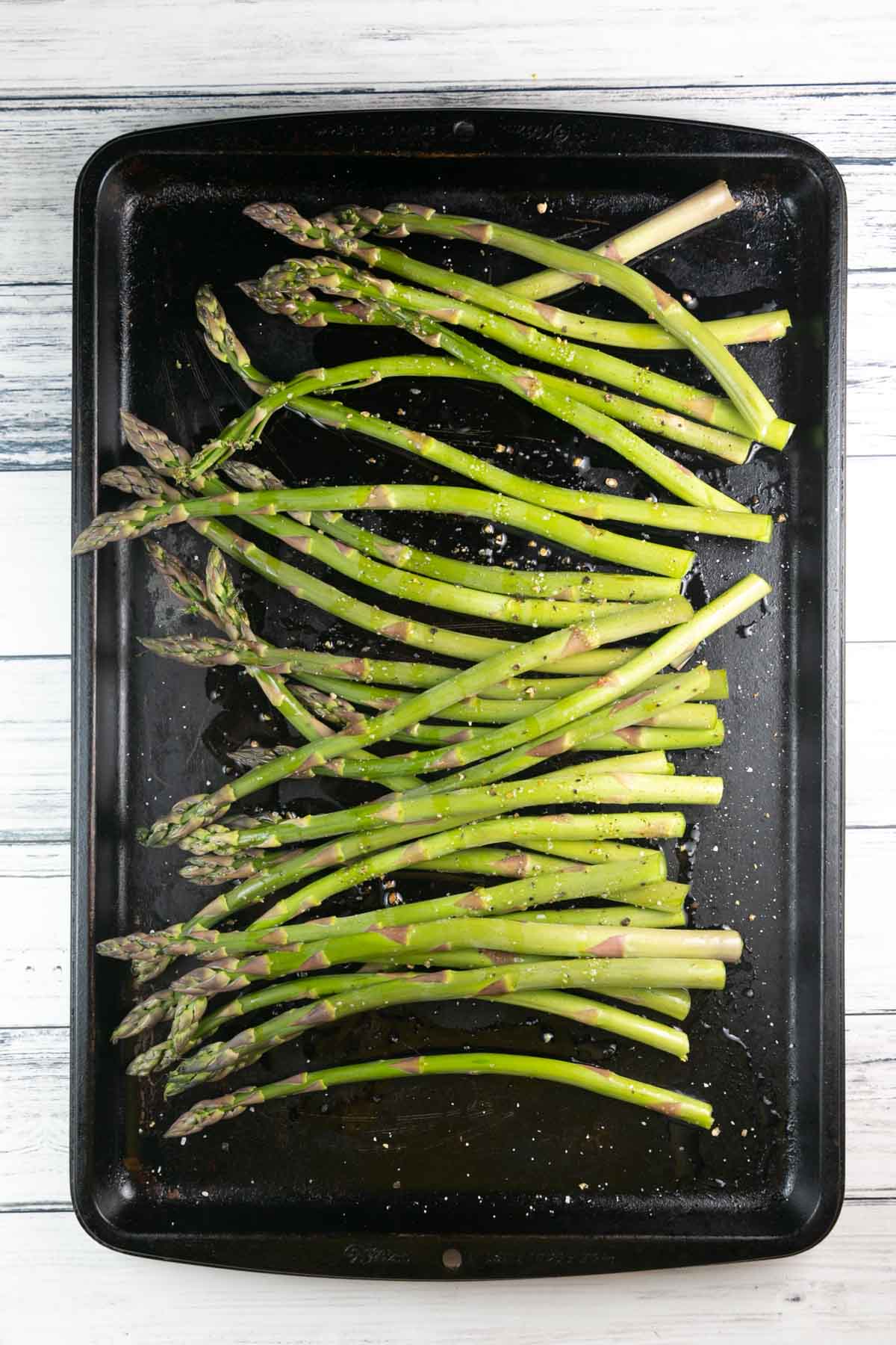 fresh asparagus tossed with olive oil and lemon on a sheet pan