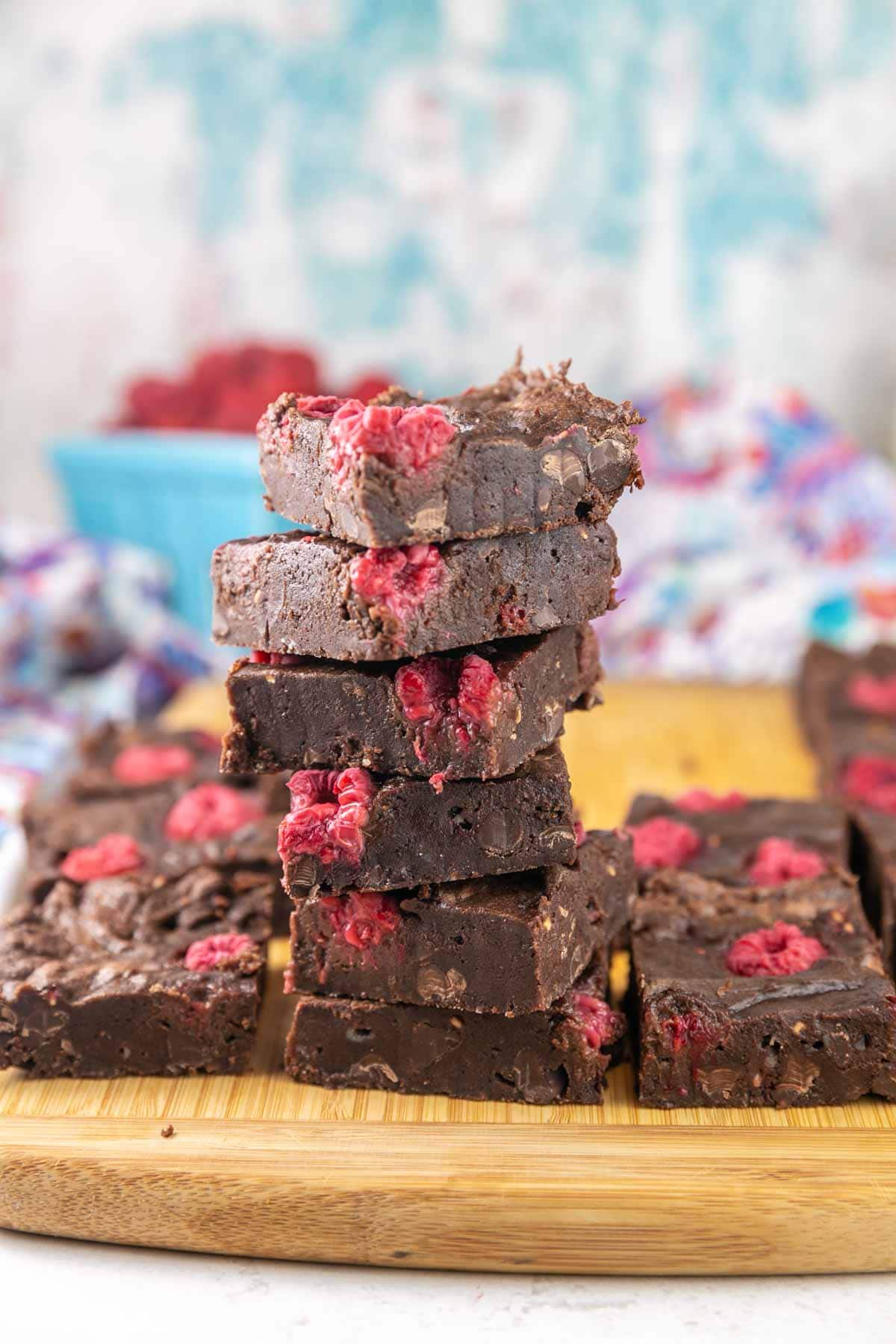 Brownies stacked on a cutting board.