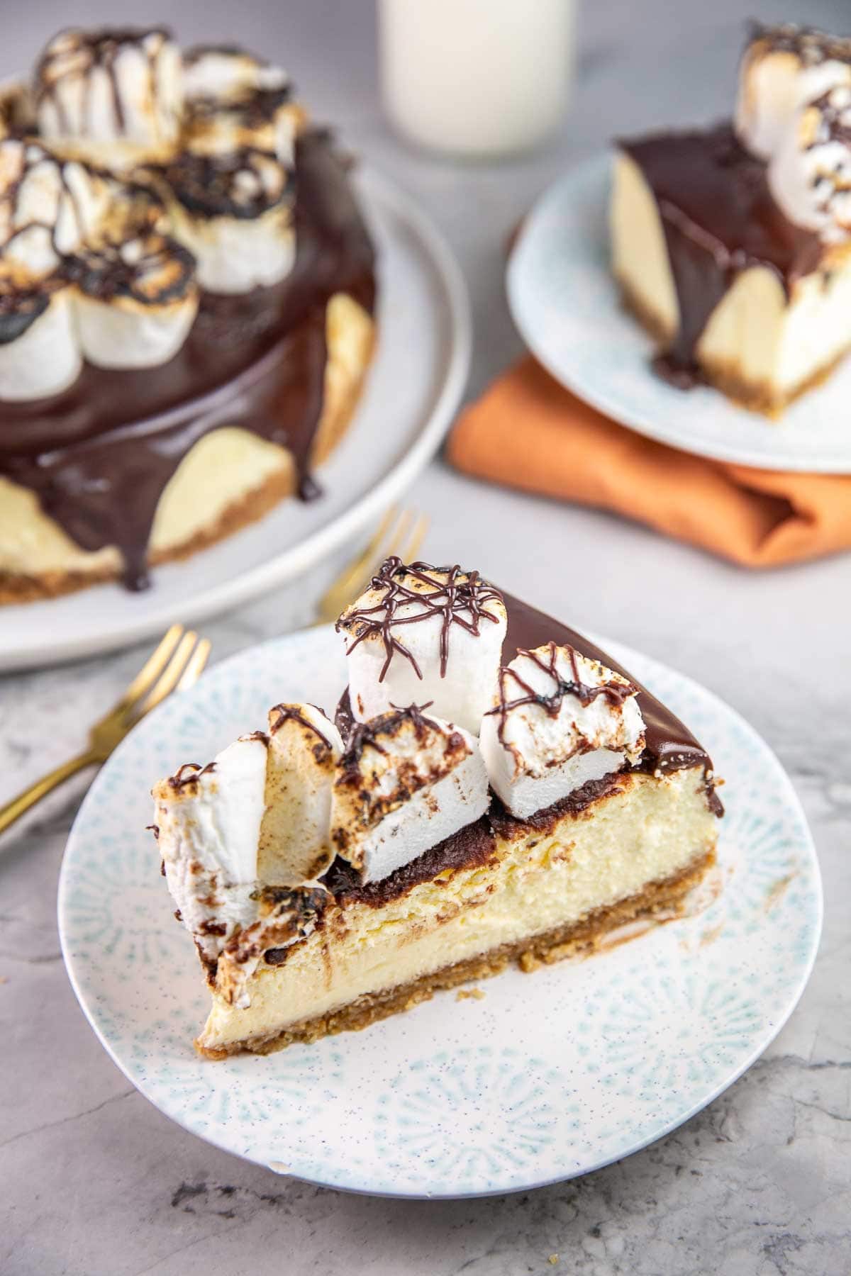 two slice of s'mores cheesecake on dessert plates