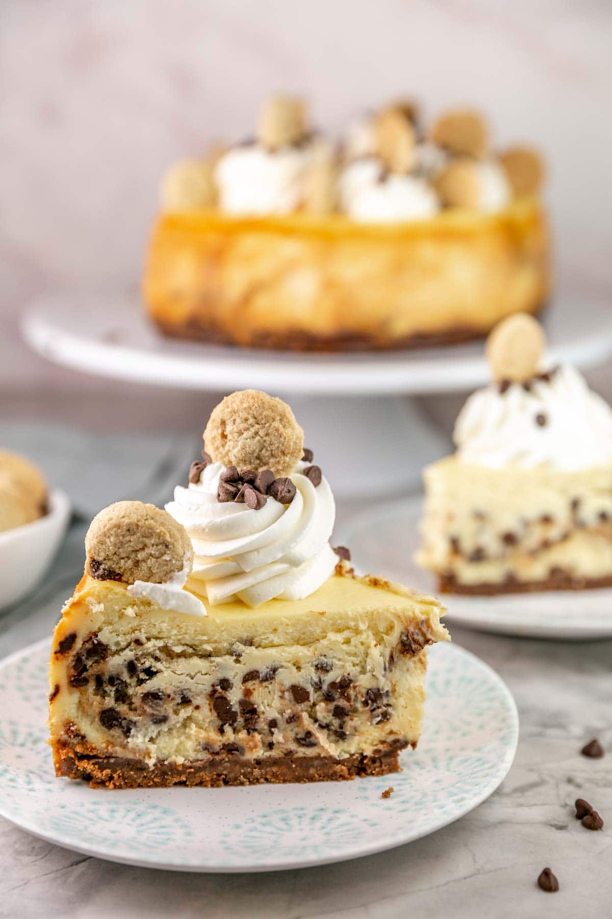 Side view of slice of cookie dough cheesecake on a plate.