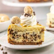 slice of chocolate chip cookie dough cheesecake with whipped cream swirls