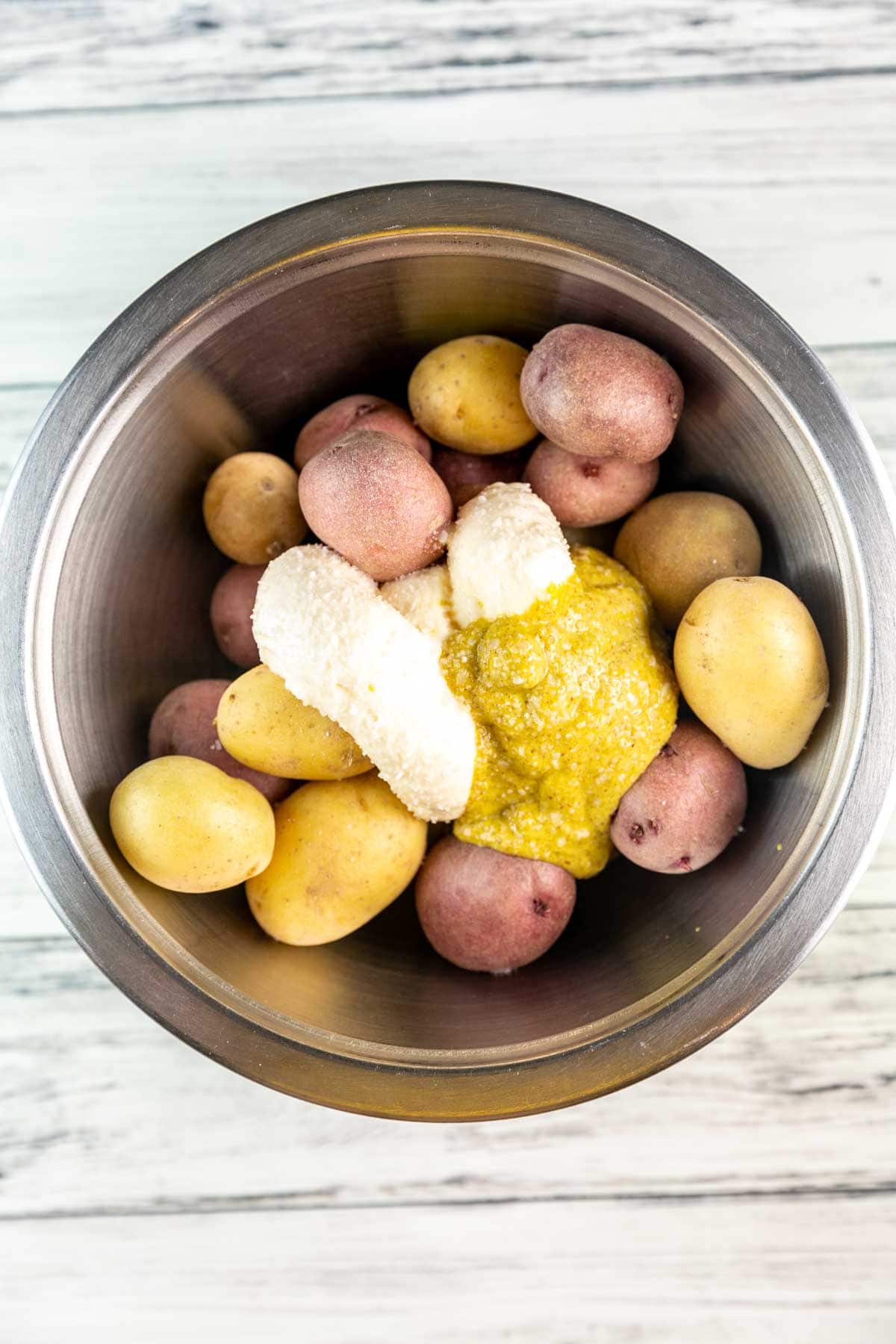 new potatoes in a bowl with mustard mayo, and salt