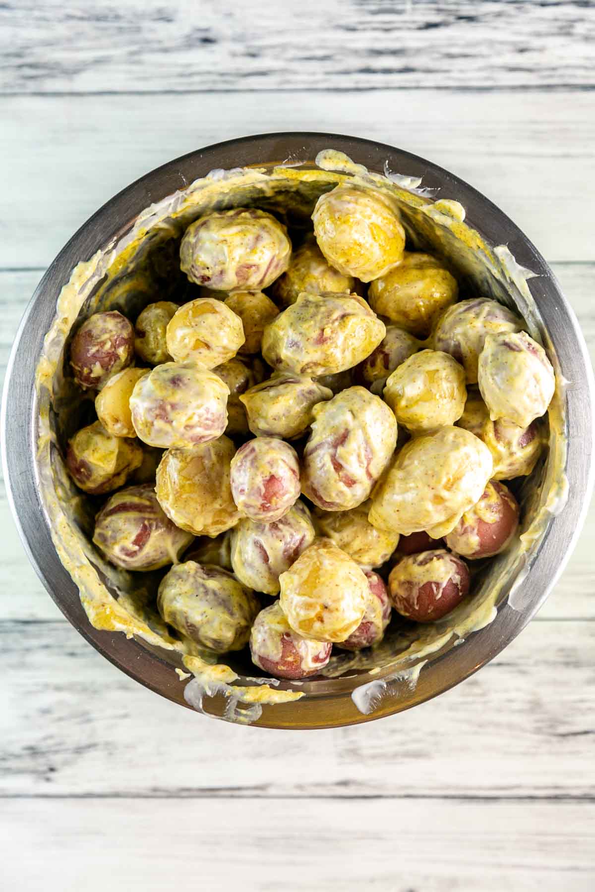 potatoes in a bowl covered with a mustard based sauce