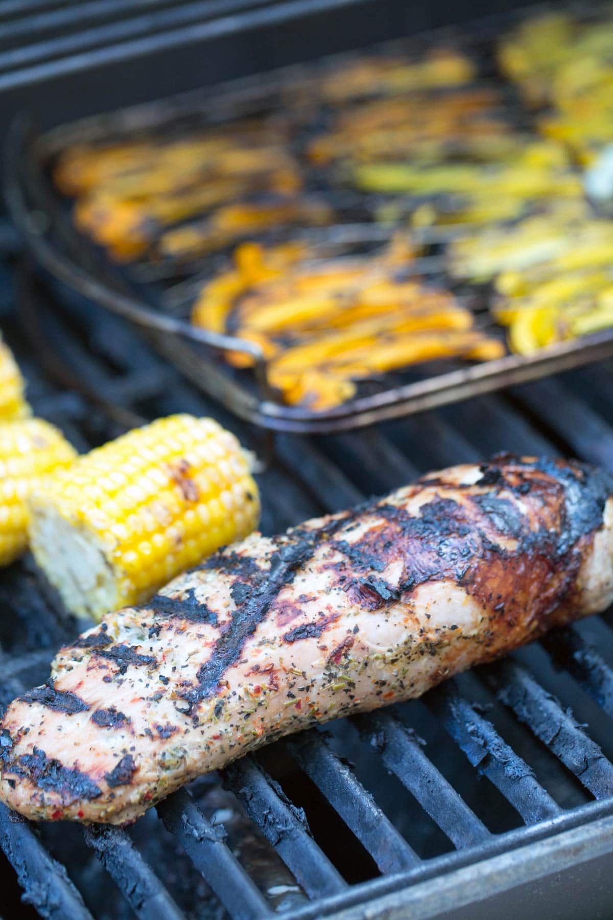 pork tenderloin and vegetables on a gas grill