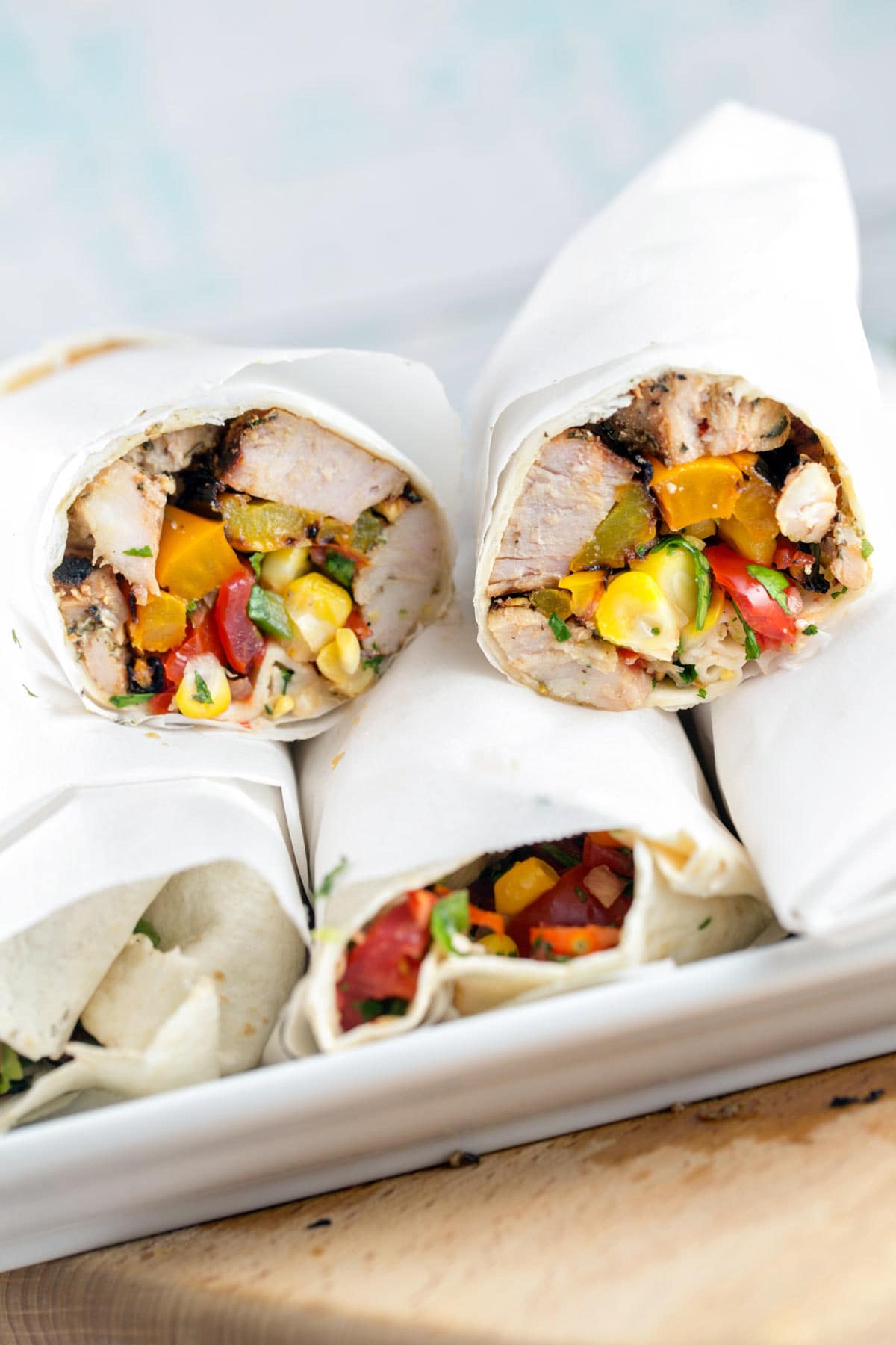 wraps rolled up in parchment paper on a serving tray