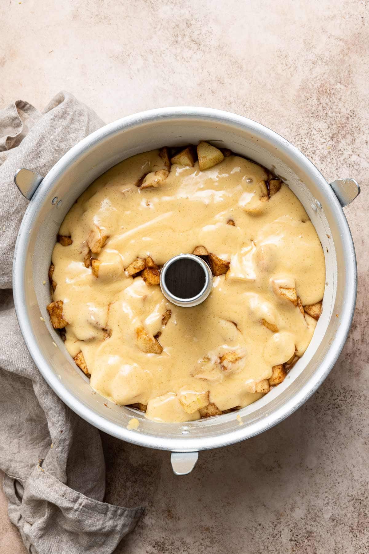 apple cake in a tube pan before baking