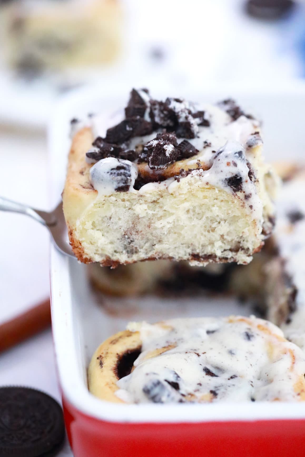 big fluffy cinnamon roll being lifted out of a pan