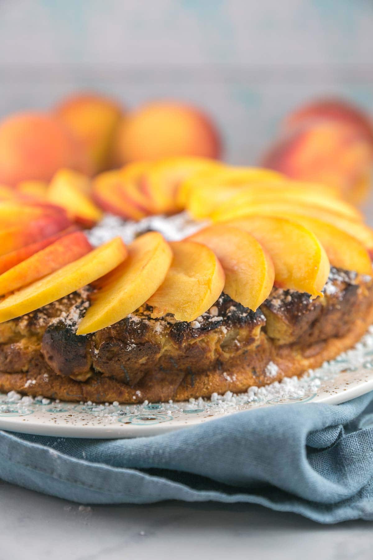 side view of a thick french toast casserole topped with sliced peaches