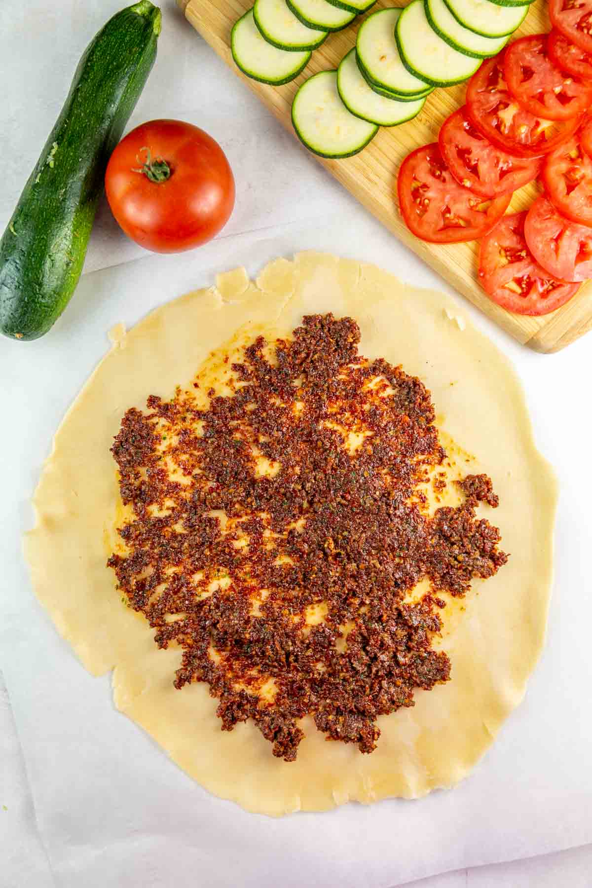 sundried tomato pesto spread on unbaked galette dough