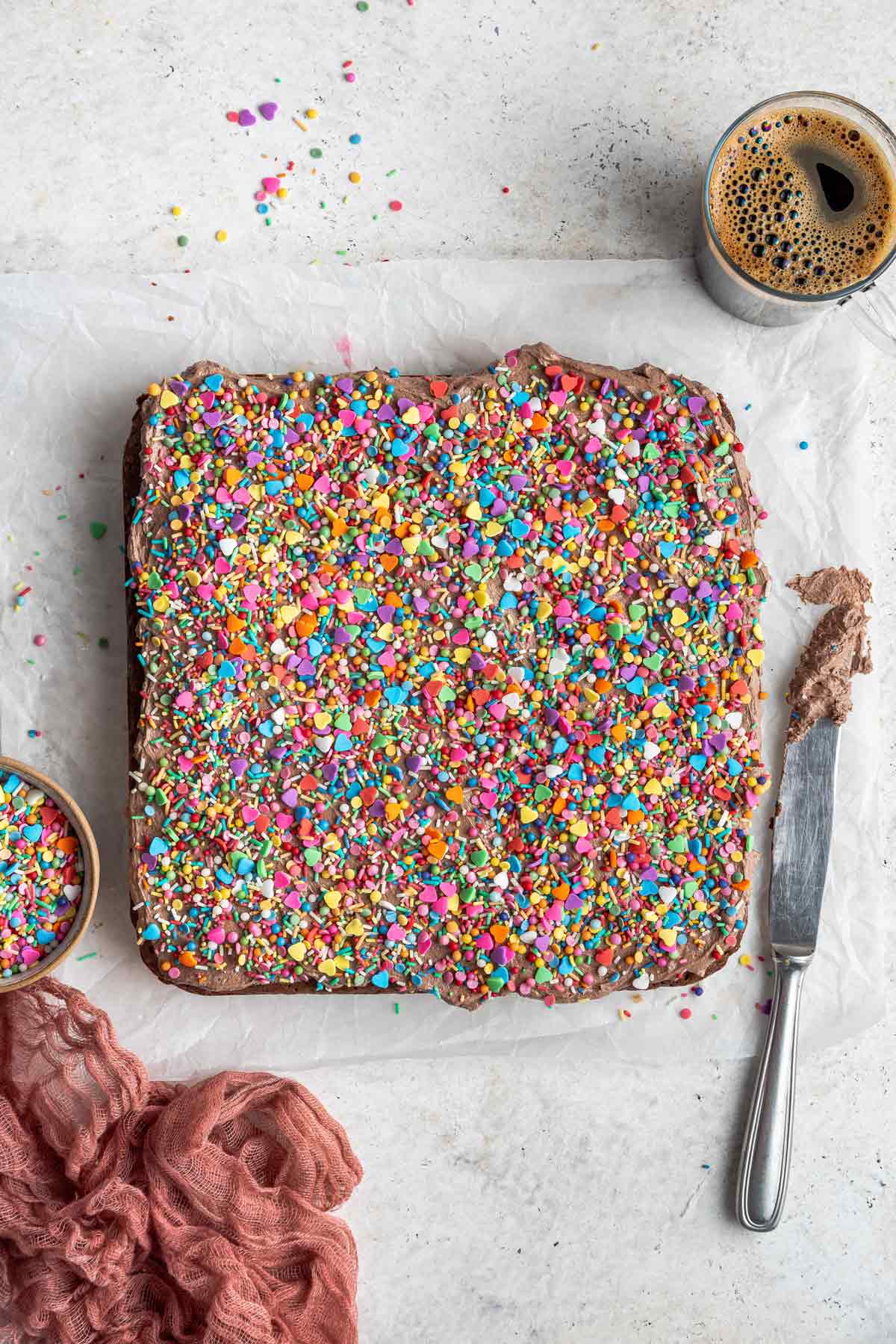 uncut brownies covered with frosting and colorful sprinkles