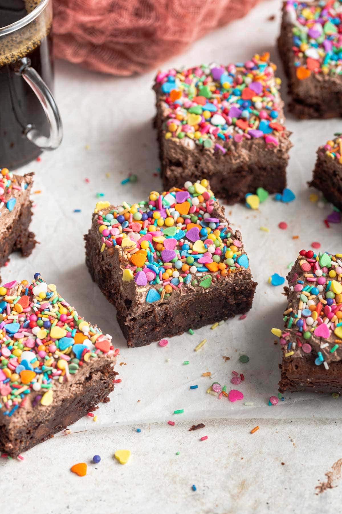 cut brownies on parchment paper surrounded by extra sprinkles