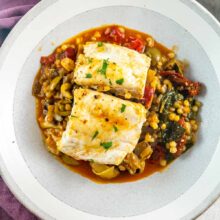 perfectly poached white fish on a bed of mediterranean vegetables and couscous