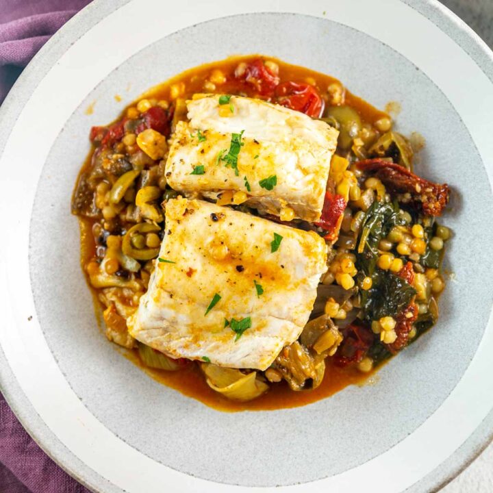 perfectly poached white fish on a bed of mediterranean vegetables and couscous