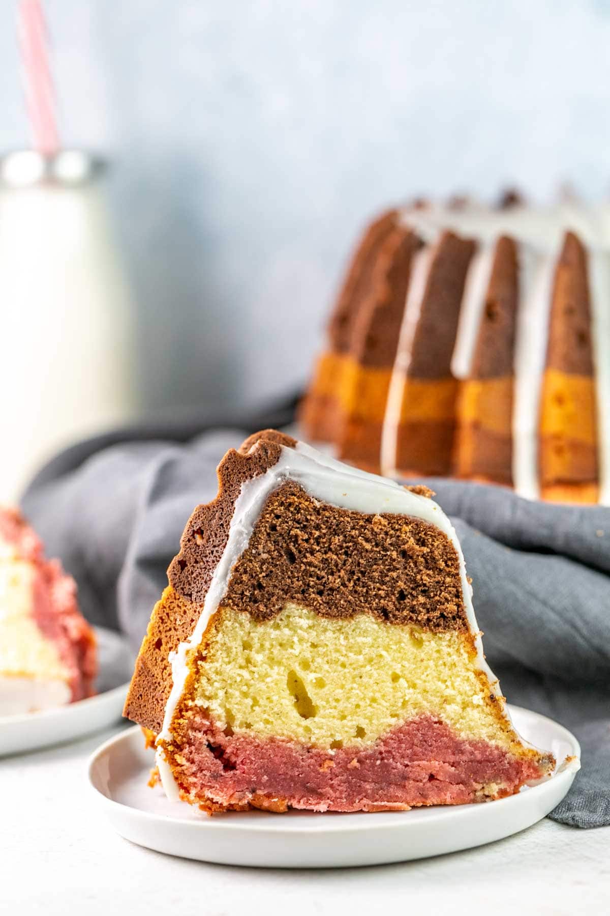 Slice of cake with three different layers on a white plate. 