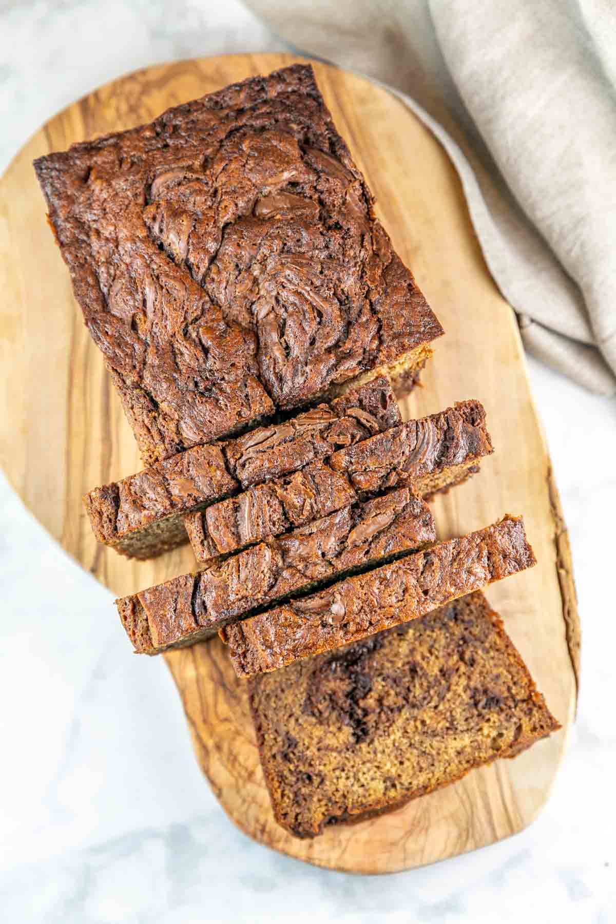 Top view of sliced Nutella banana bread on a wooden cutting board. 