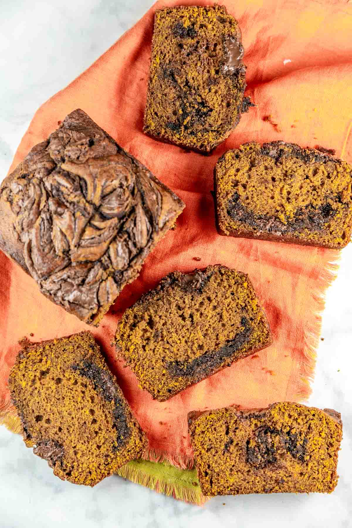 slices of nutella pumpkin bread on an orange kitchen towel.