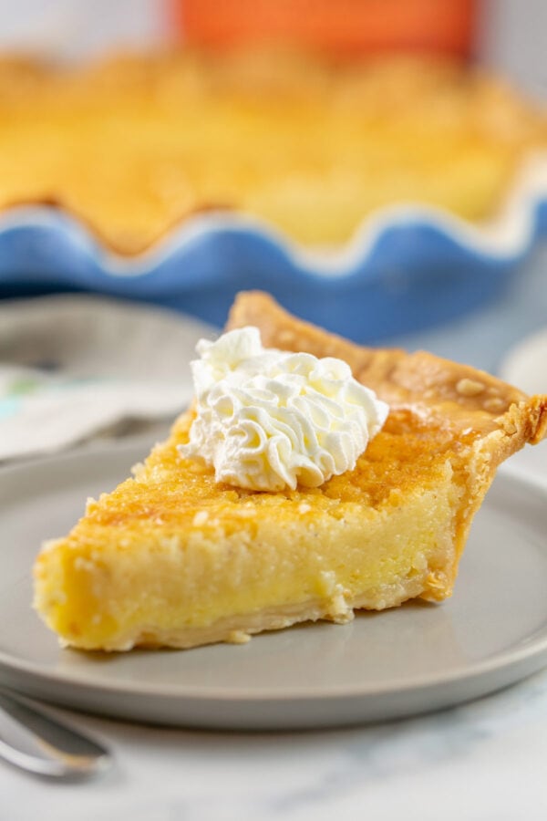 single slice of buttermilk pie with a dollop of bourbon whipped cream