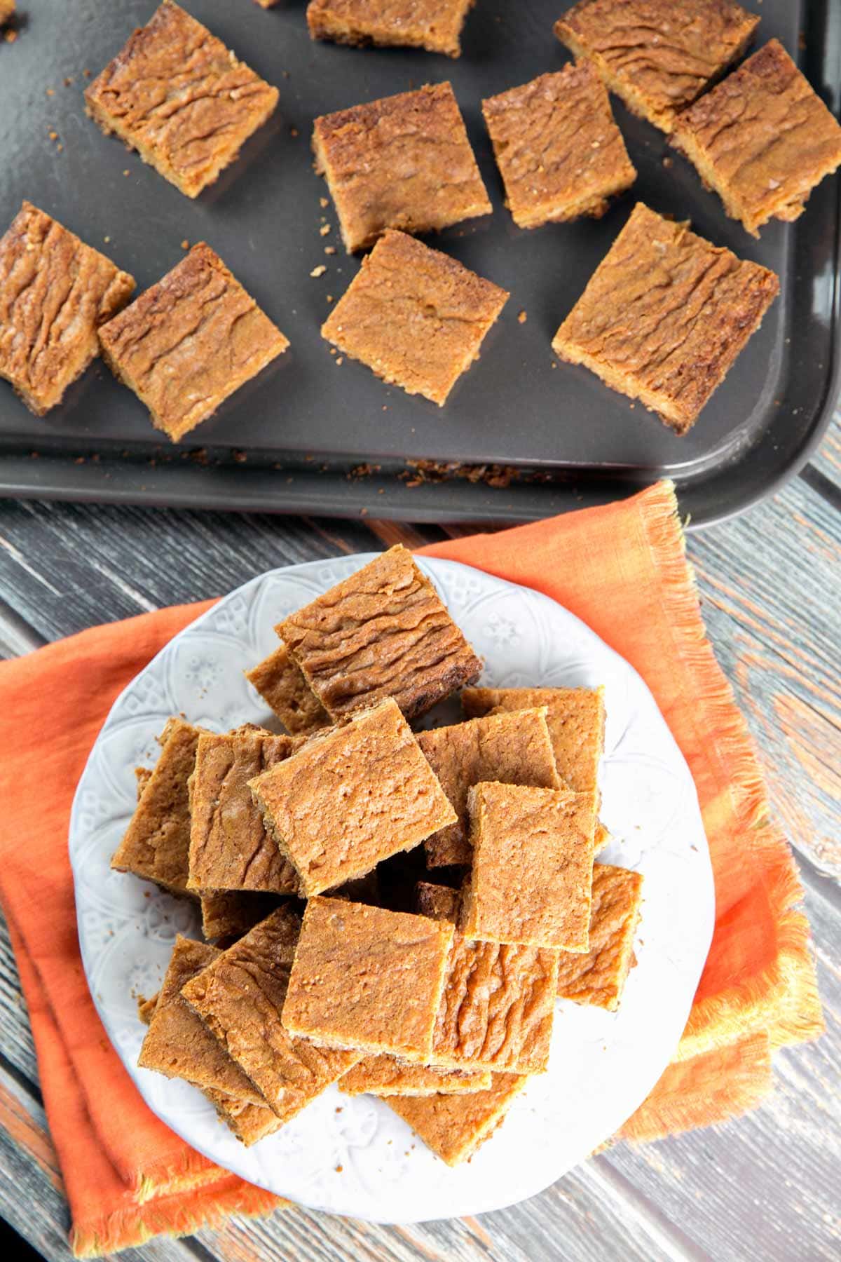 plate full of blondies on an orange kitchen towel