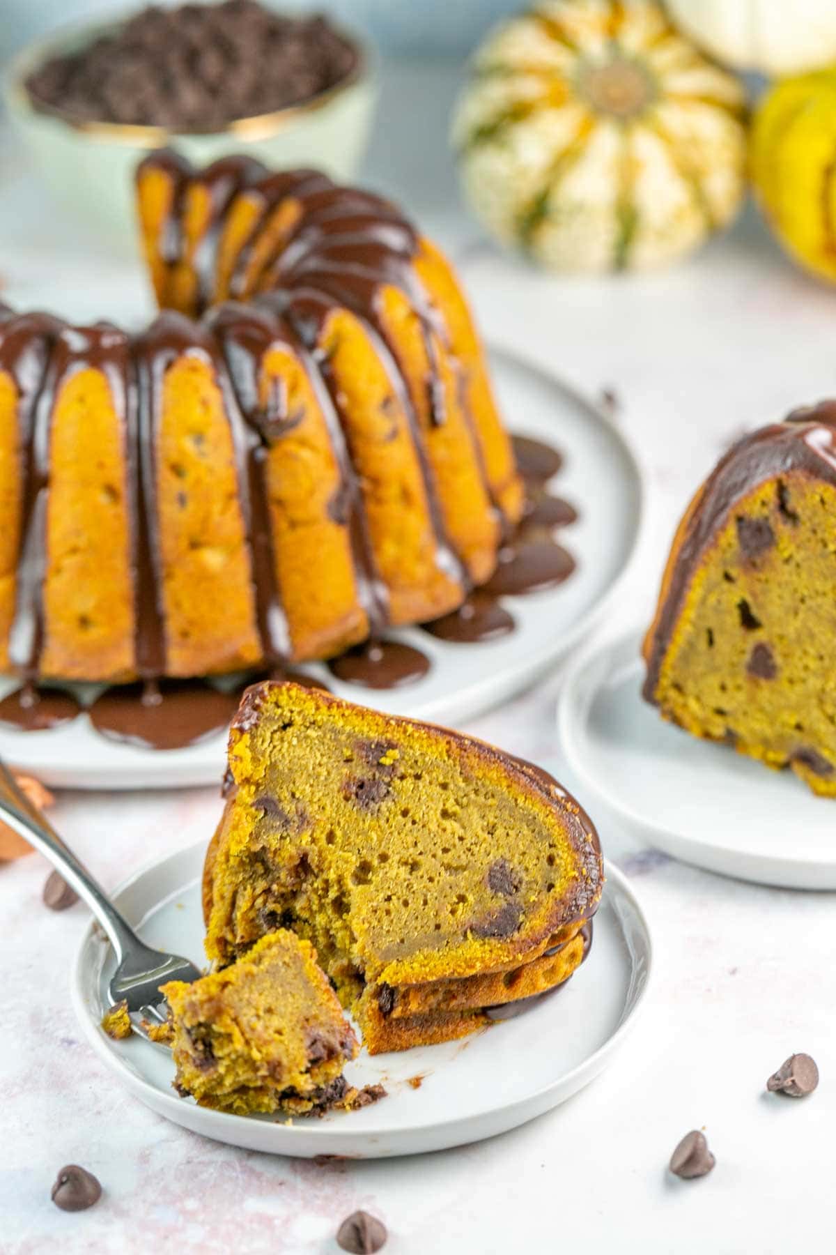 slice of pumpkin bundt cake on a plate with a fork removing one bite