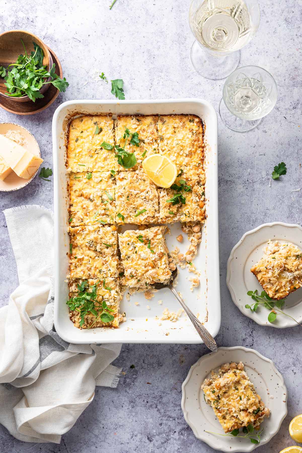 casserole cut into squares with pieces served on small plates.