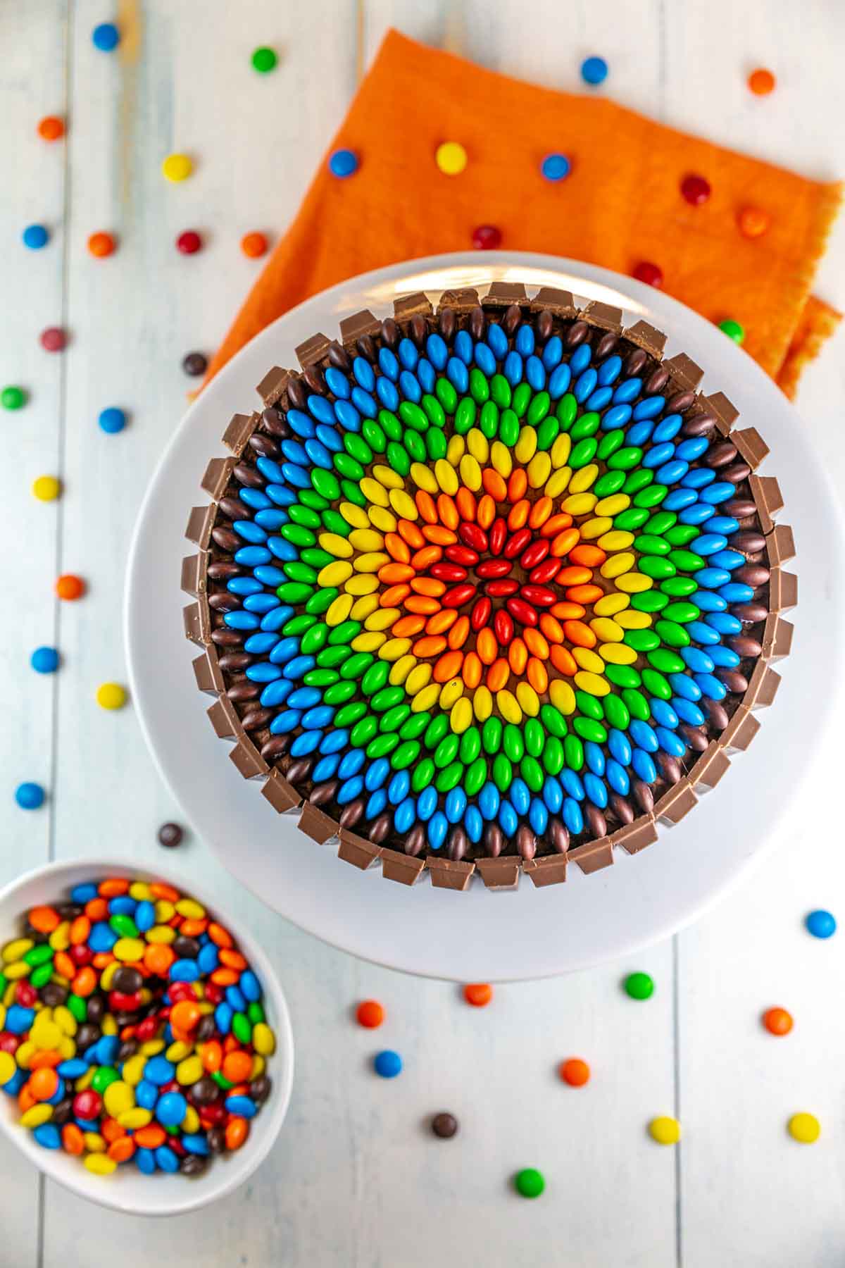 Top view of m&m layer cake with m&ms arranged on top in a rainbow. 