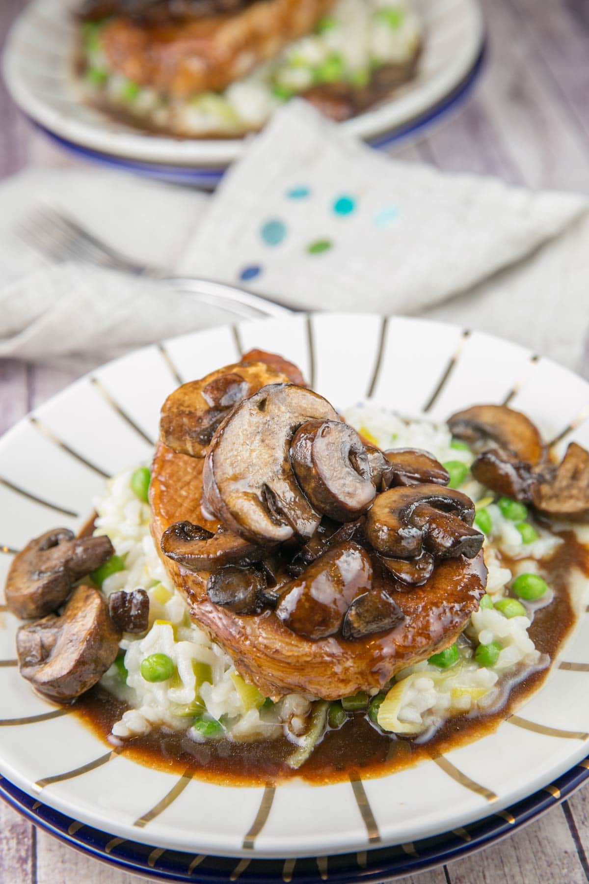 two plates with pork chops and a mushroom balsamic glaze