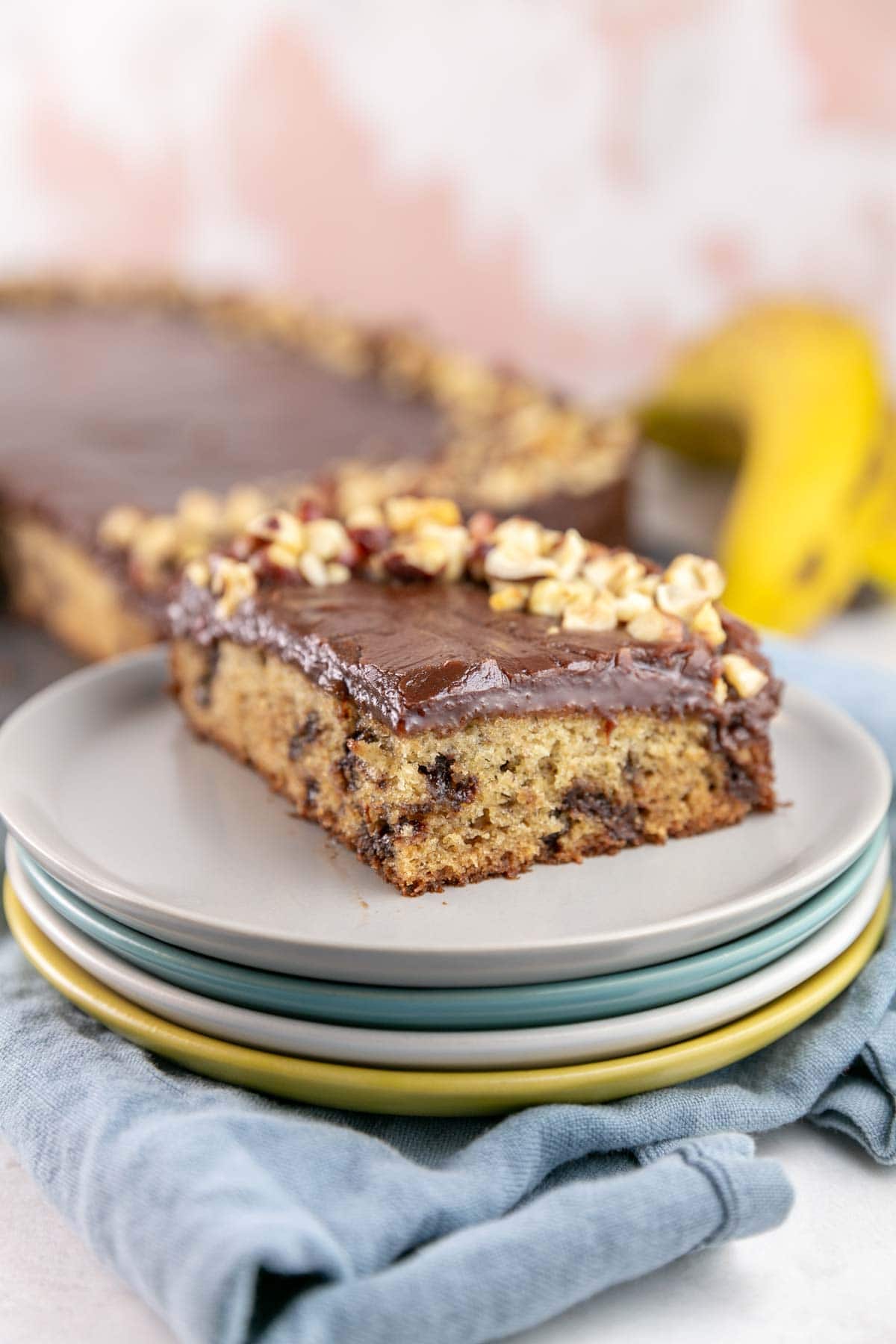 slice of banana cake with chocolate chips on a stack of dessert plates