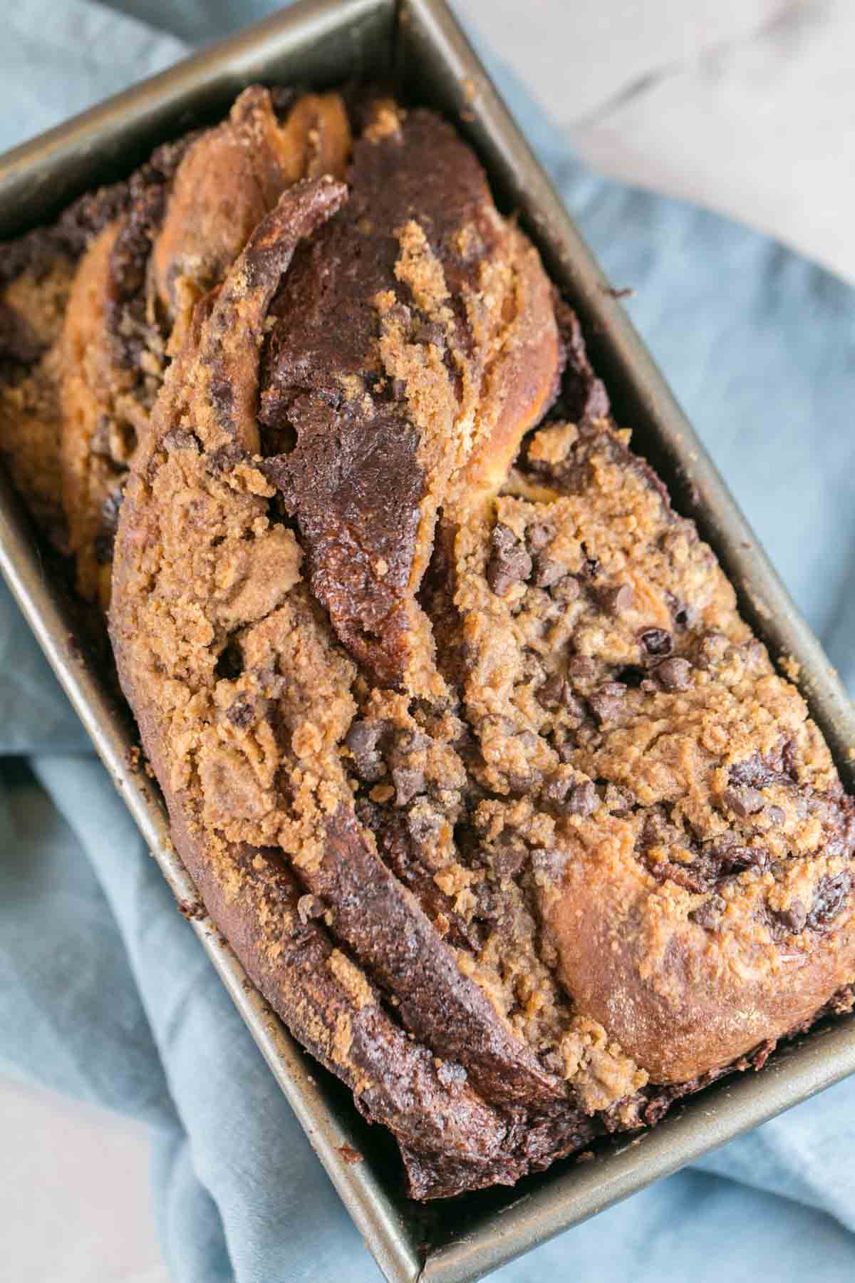 baked loaf of streusel covered chocolate babka in a loaf pan