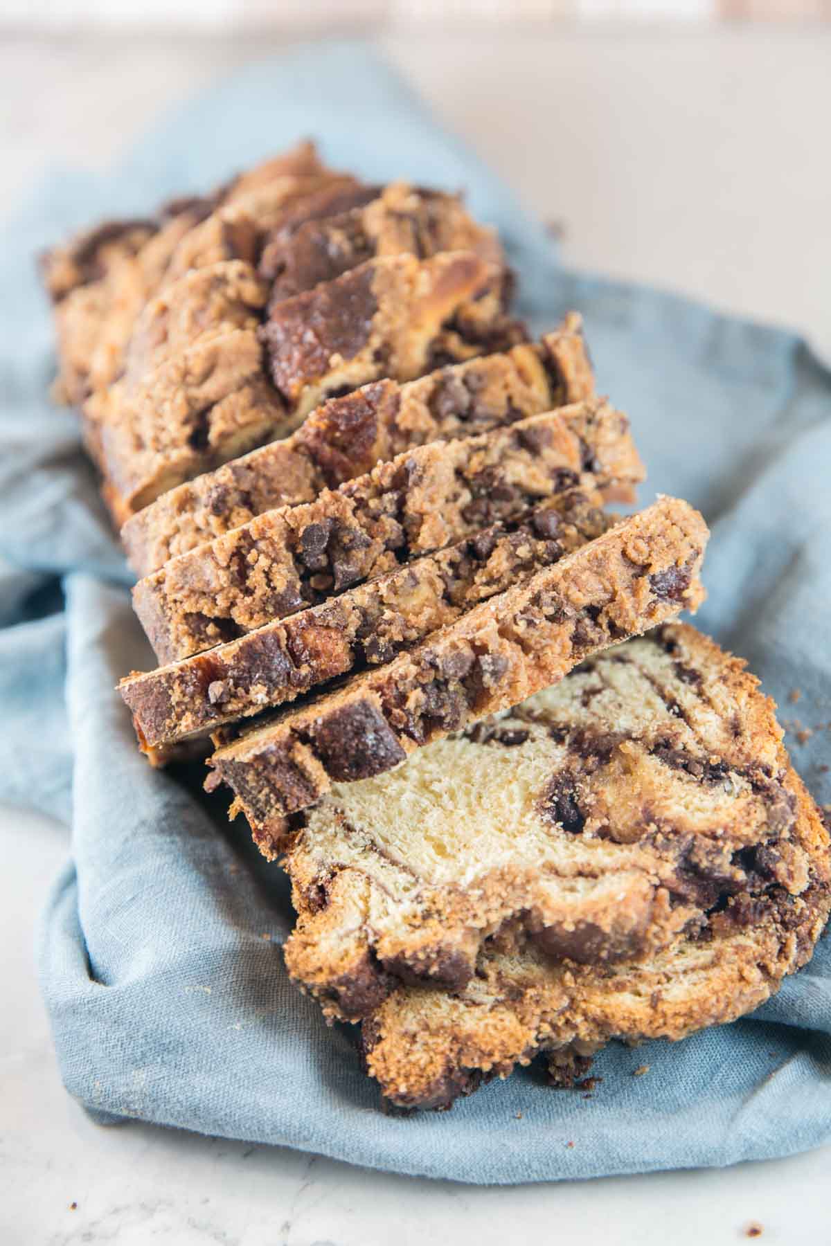 sliced loaf of chocolate babka on a blue dishtowel