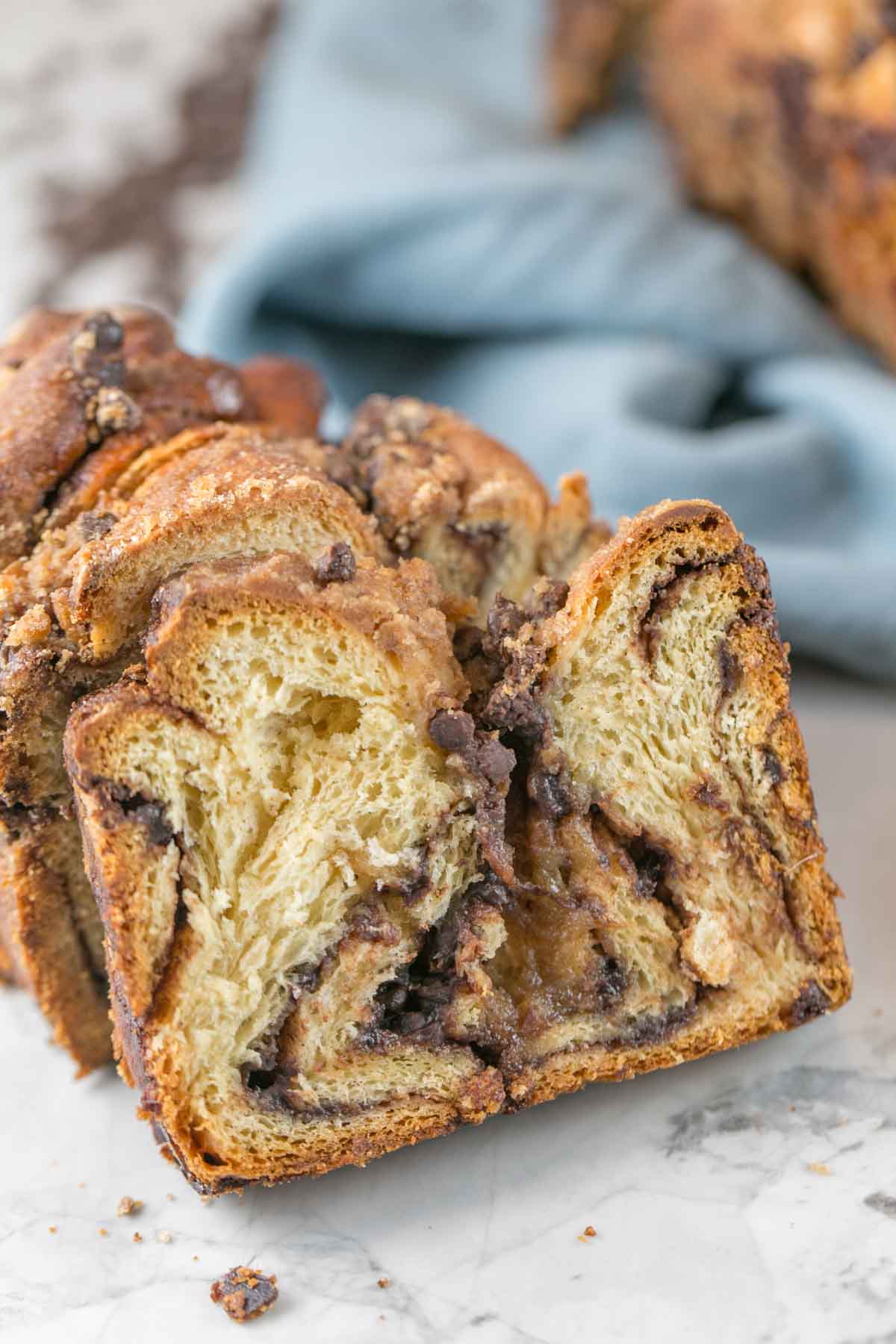 a slice of chocolate babka showing the rich gooey chocolate swirled center