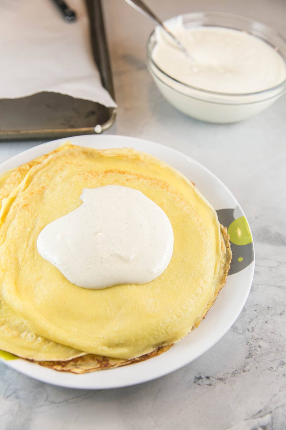 a pile of crepes with a dollop of ricotta blintz filling in the center