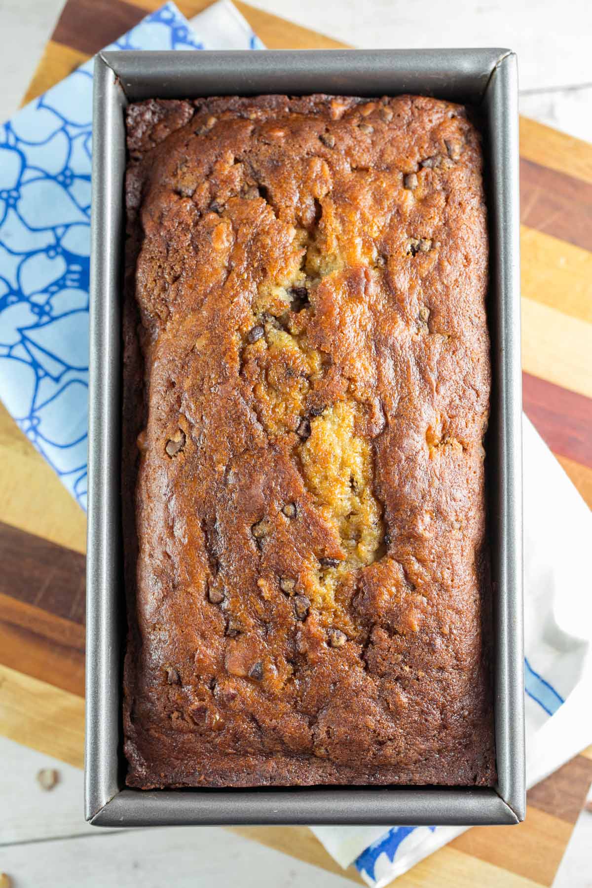 a loaf of chocolate chip banana bread with hazelnuts in the loaf pan