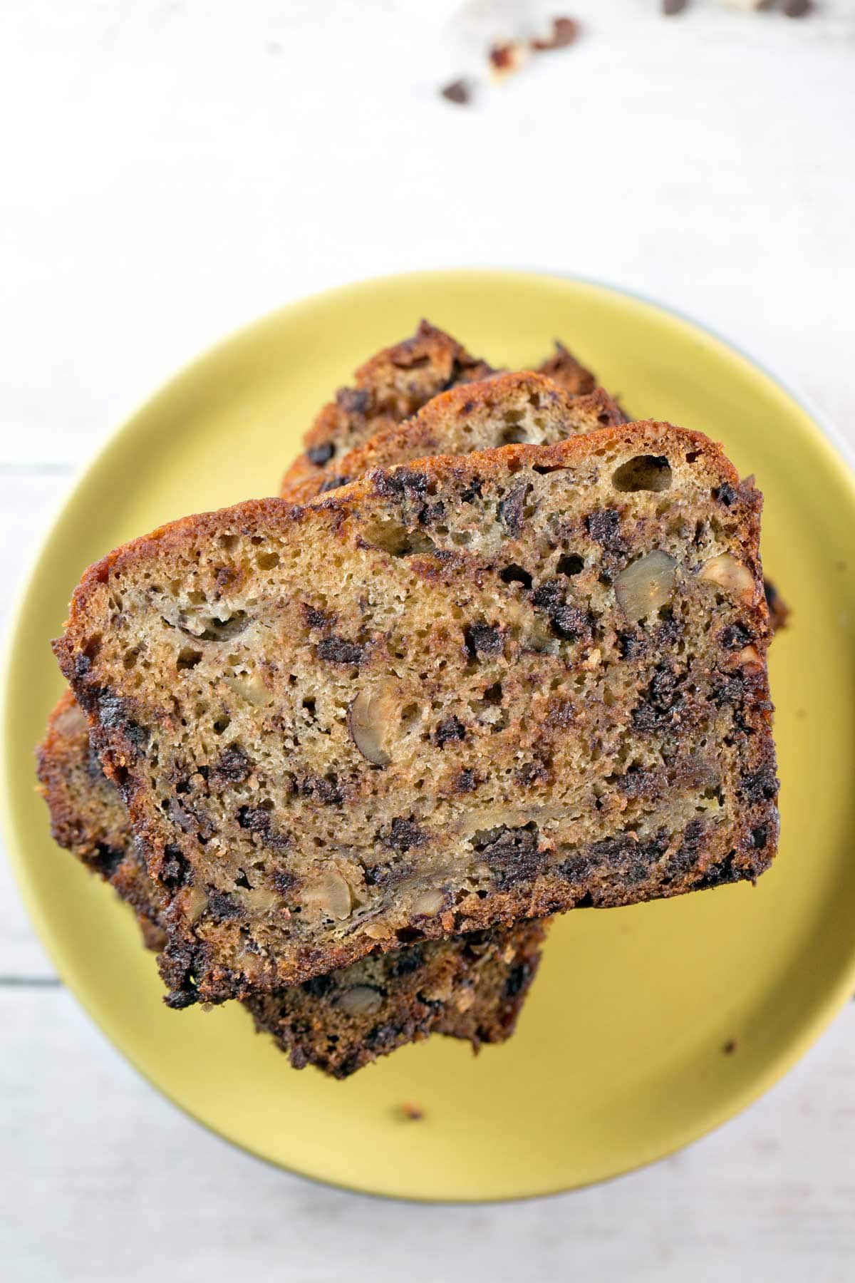 slices of banana bread stacked on on a yellow plate