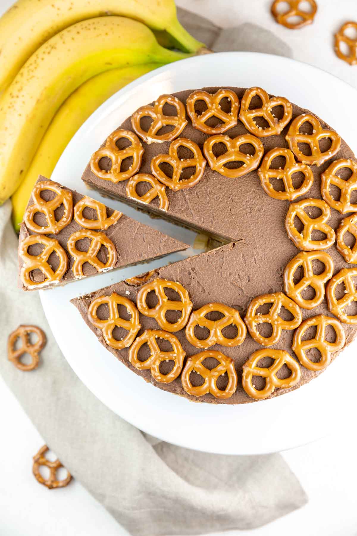 one slice partially removed from a pie covered with pretzels on top
