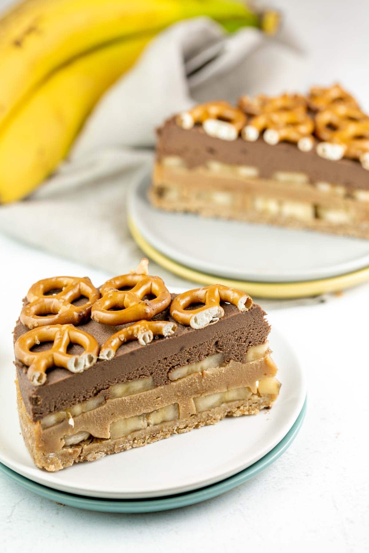 slice of pie showing the layers of crust, peanut butter ganache, chocolate ganache, and sliced bananas