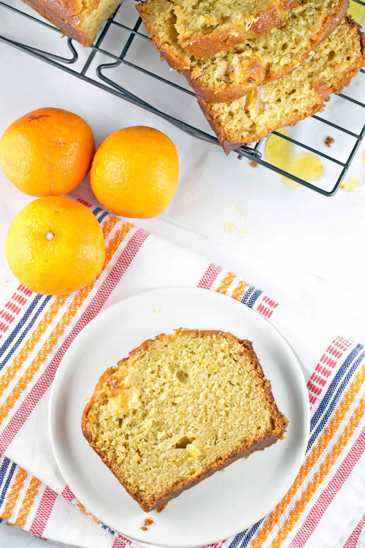 slice of quick bread on a plate next to three clementines