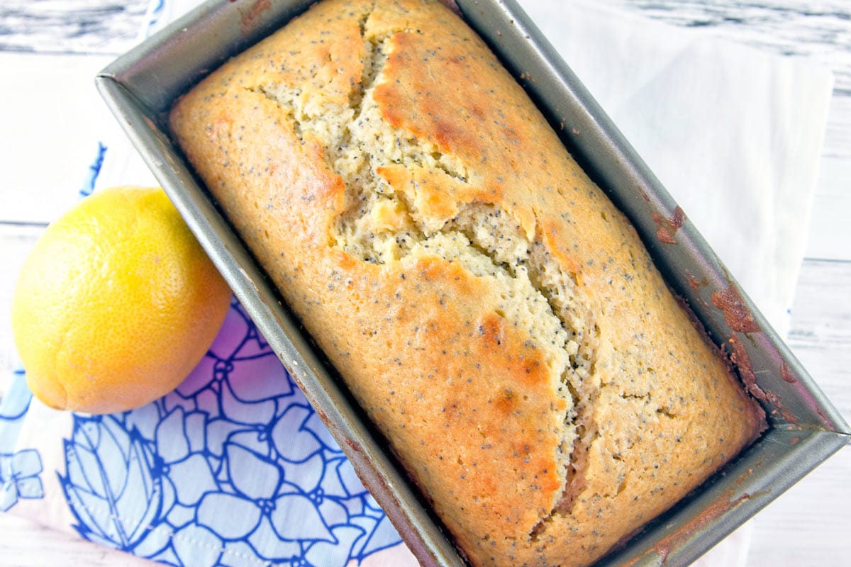 freshly baked loaf of lemon loaf still in the baking pan