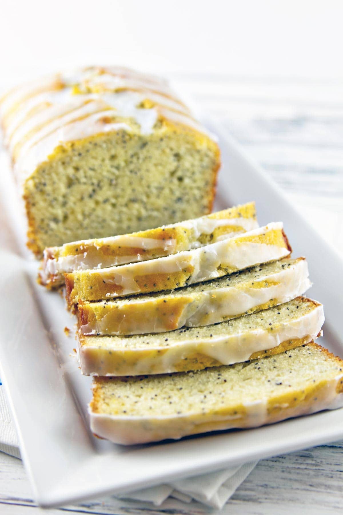 slices of lemon quick bread showing all the poppy seeds in the interior of the bread