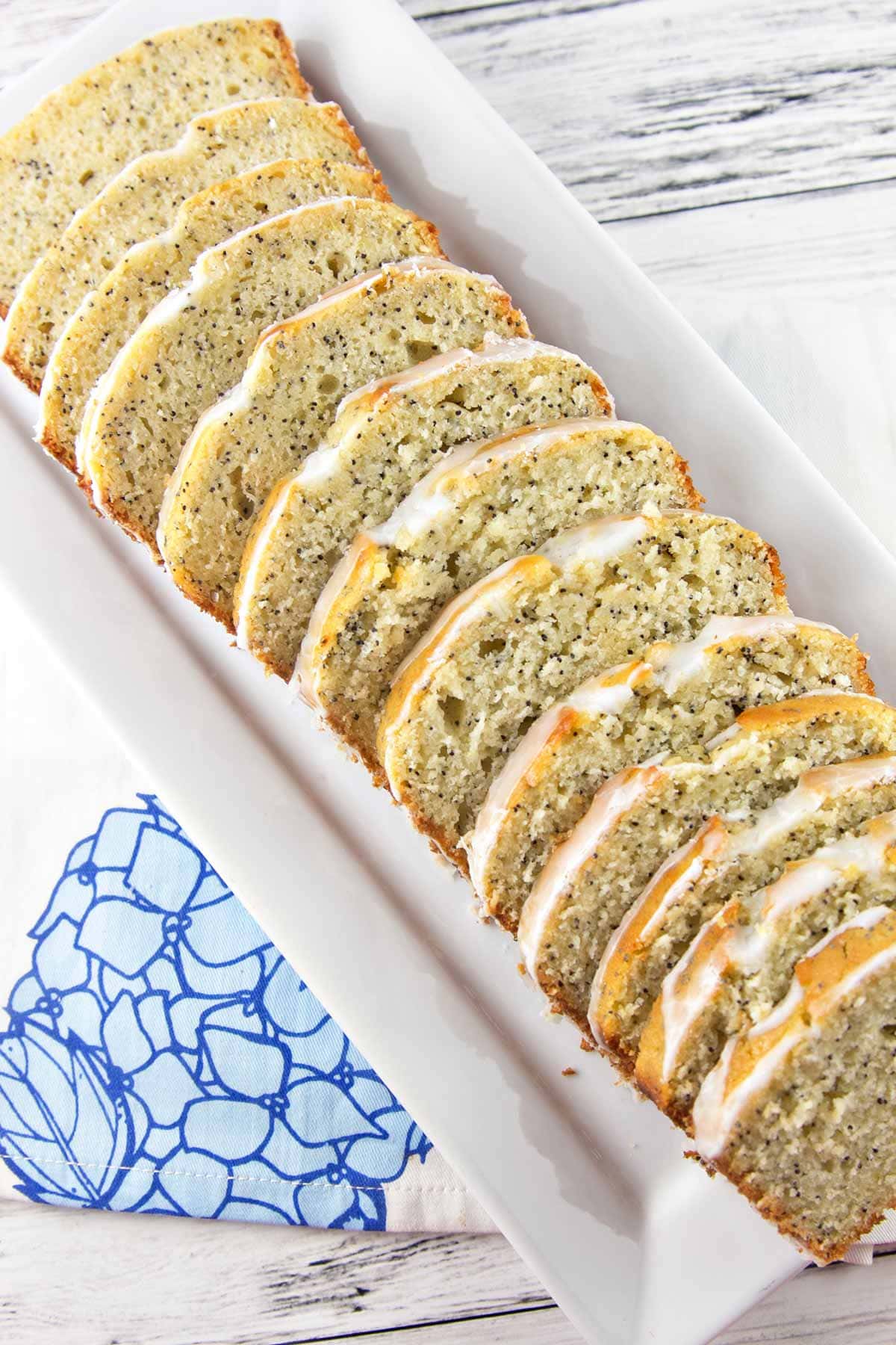 slices of lemon poppy seed bread arranged on a rectangular white serving plate