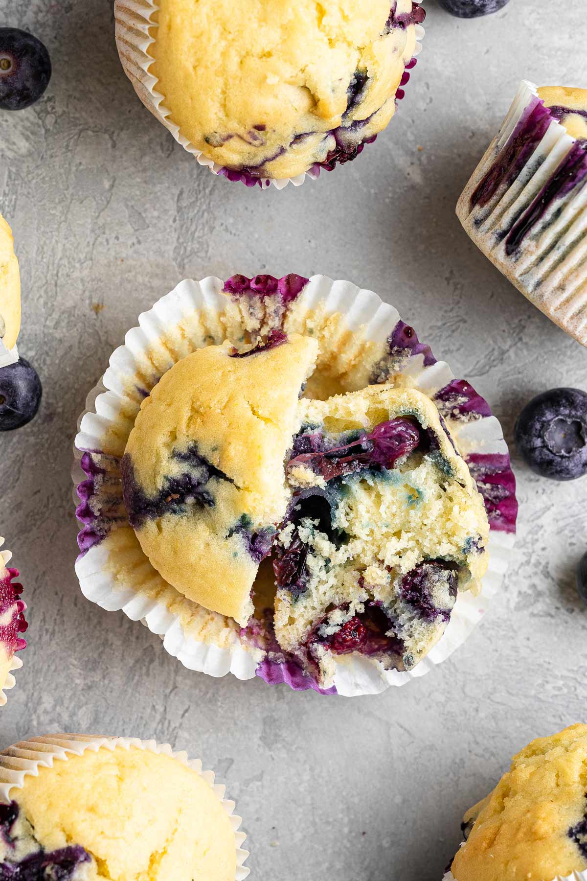 muffin cut open to show the fluffy texture and blueberries inside