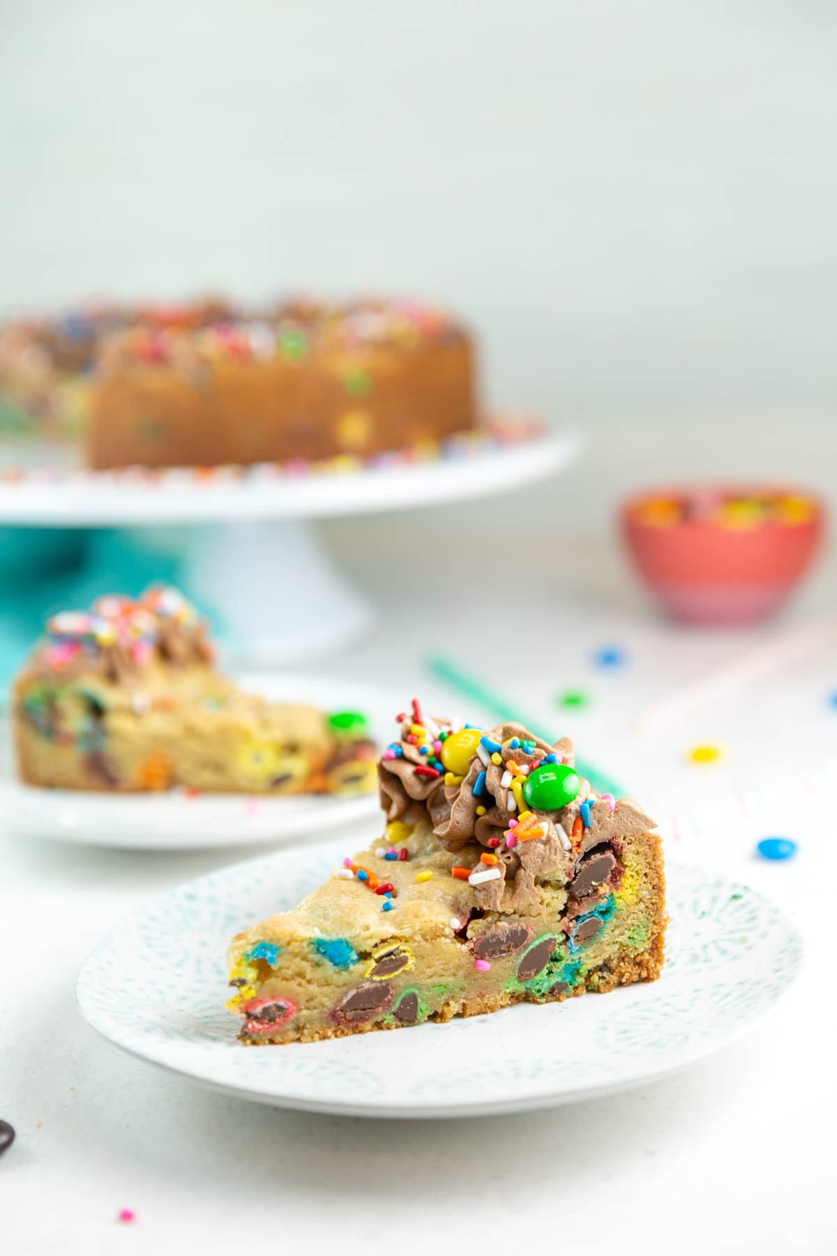 a slice of m&m cookie cake on a small dessert plate