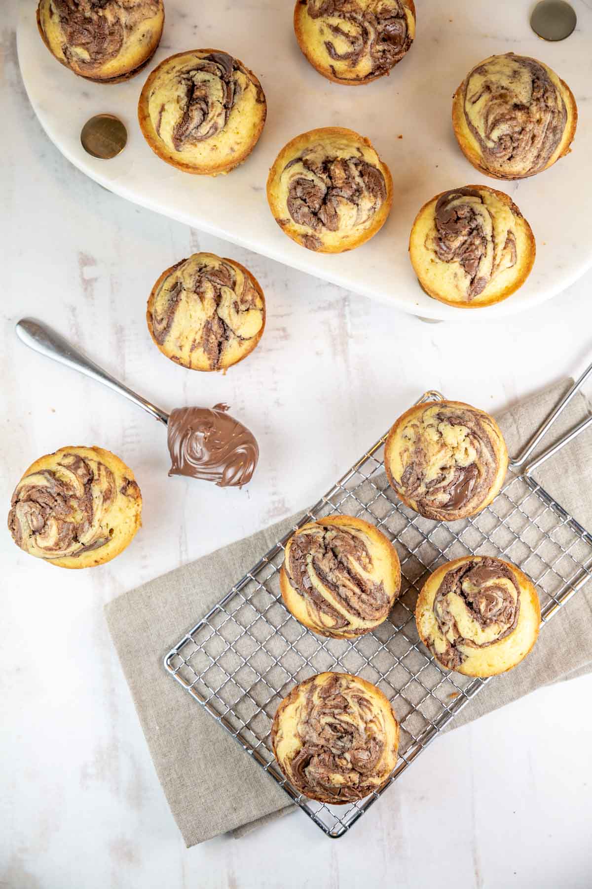 large nutella swirl cupcakes next to spoonful of nutella