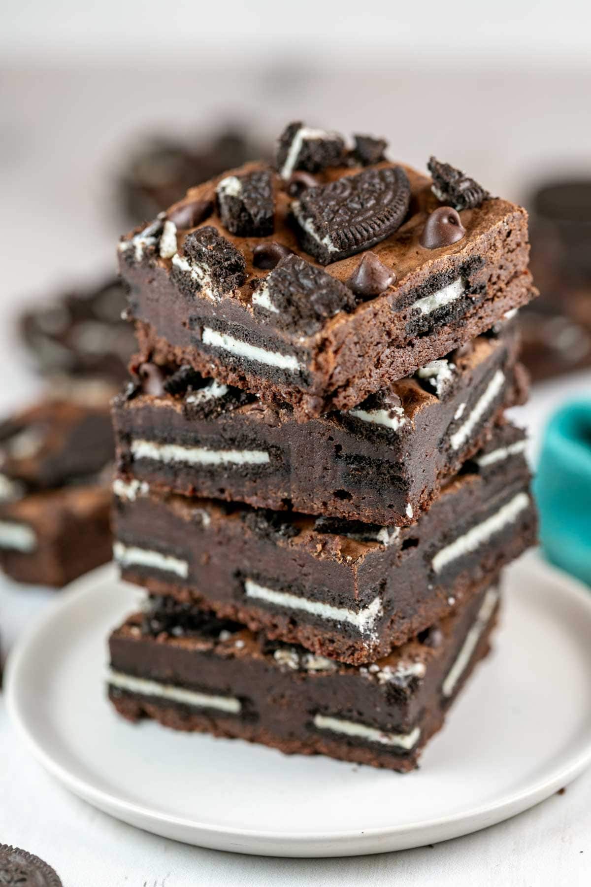 four brownies stacked on a plate with a layer of oreos in the middle