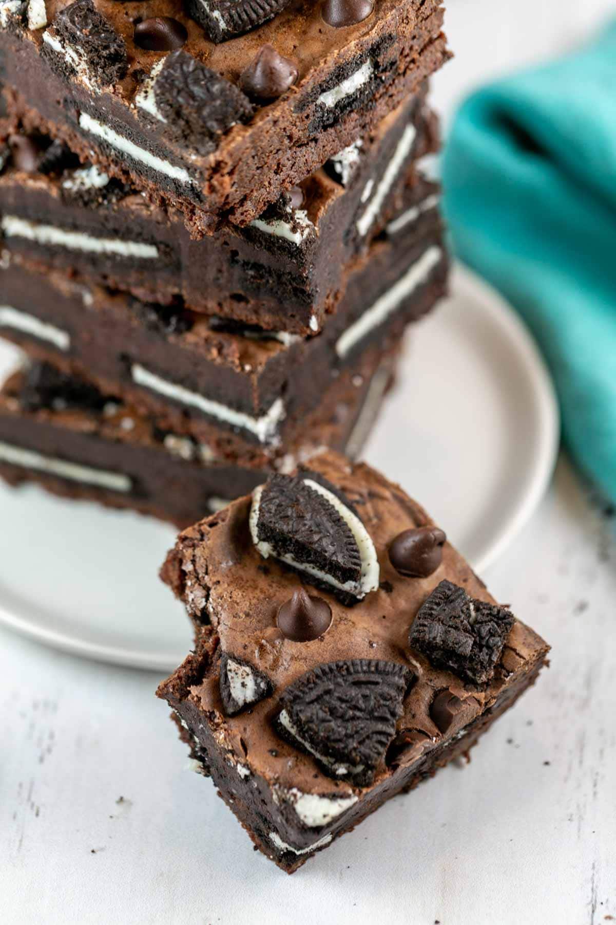 a stack of brownies on a plate with a bite taken out of one