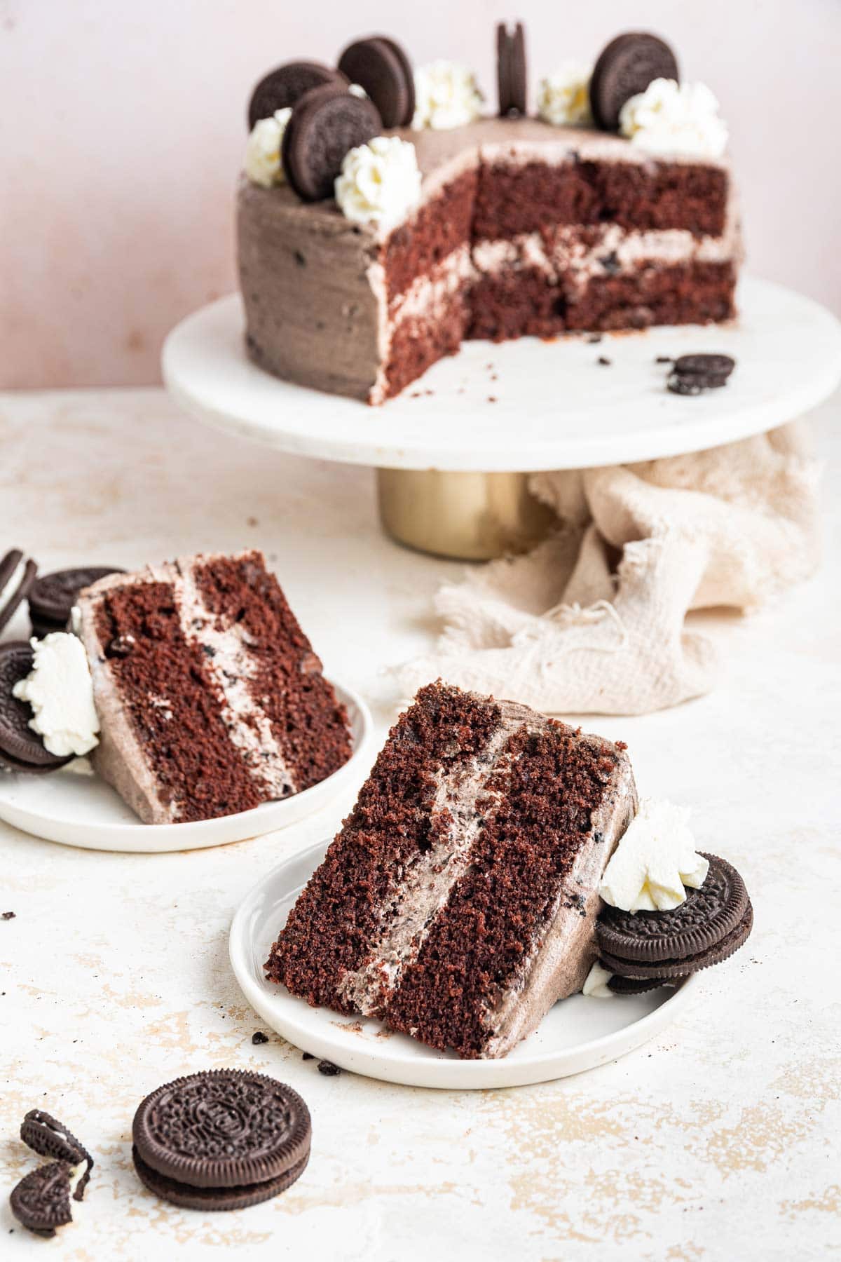 two slices of cake surrounded by oreos and whipped cream