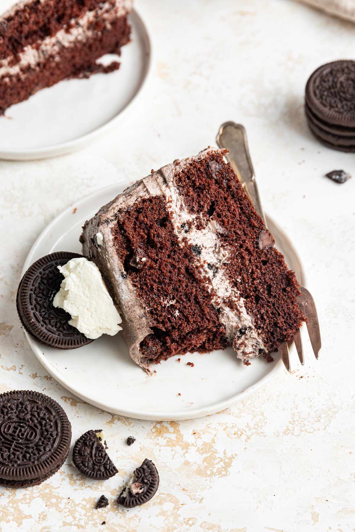 oreo layer cake on a dessert plate with a few bites removed