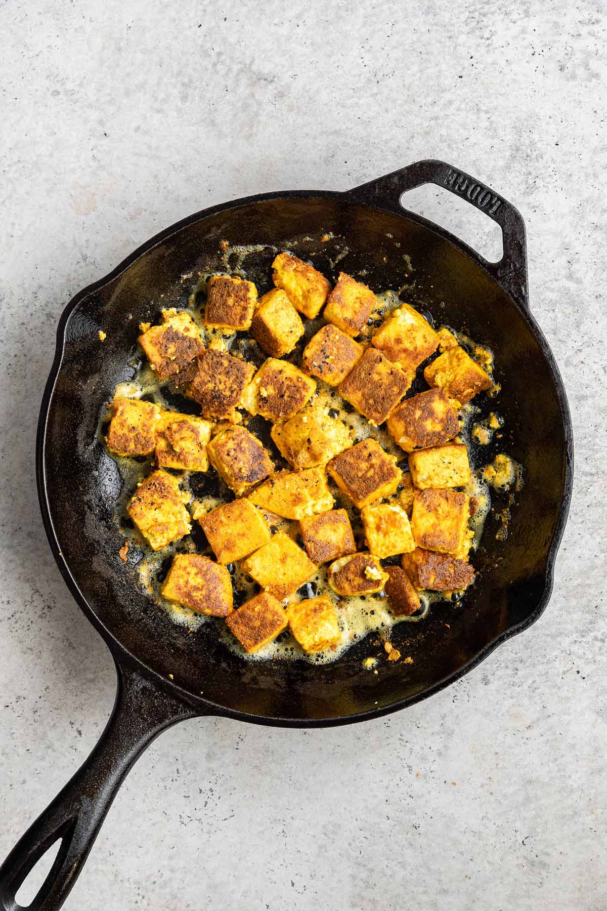 sauteeing paneer in a cast iron skillet