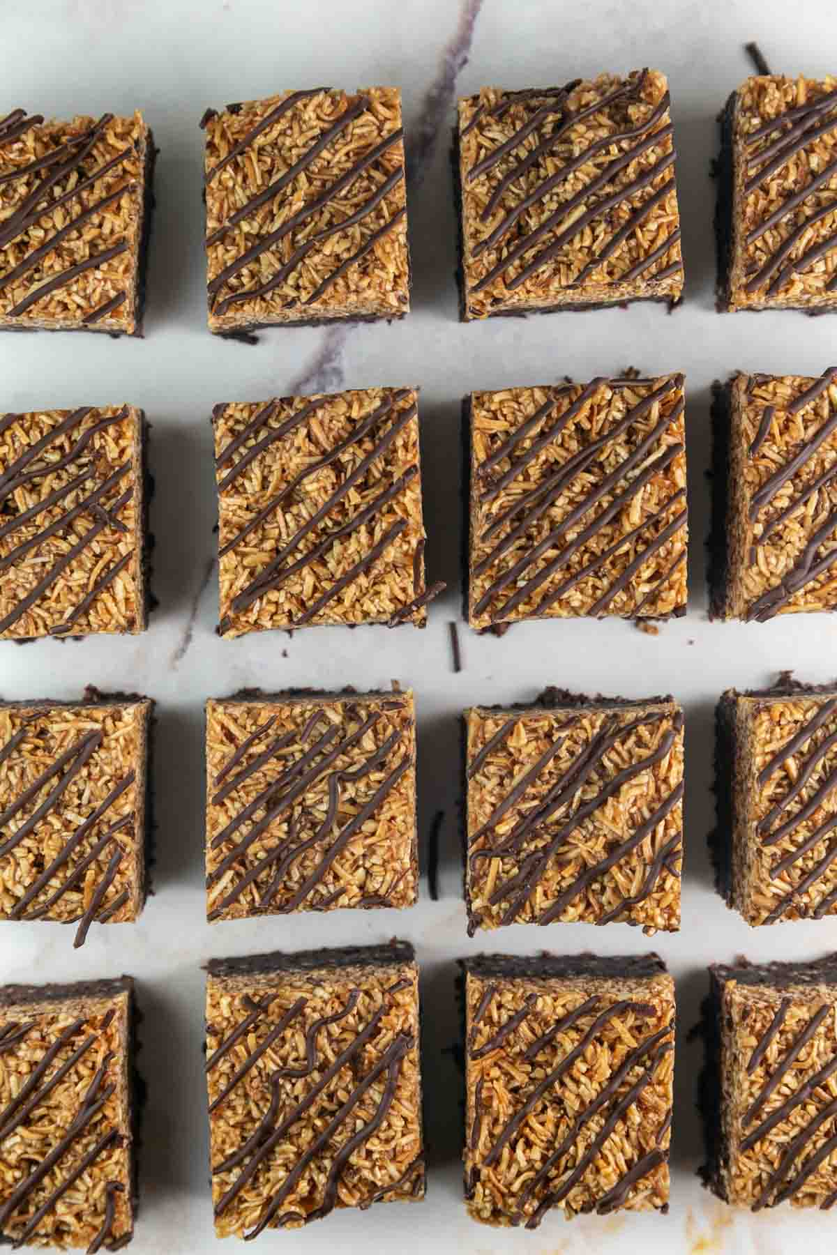 thick brownies with coconut caramel topping and diagonal drizzles of chocolate