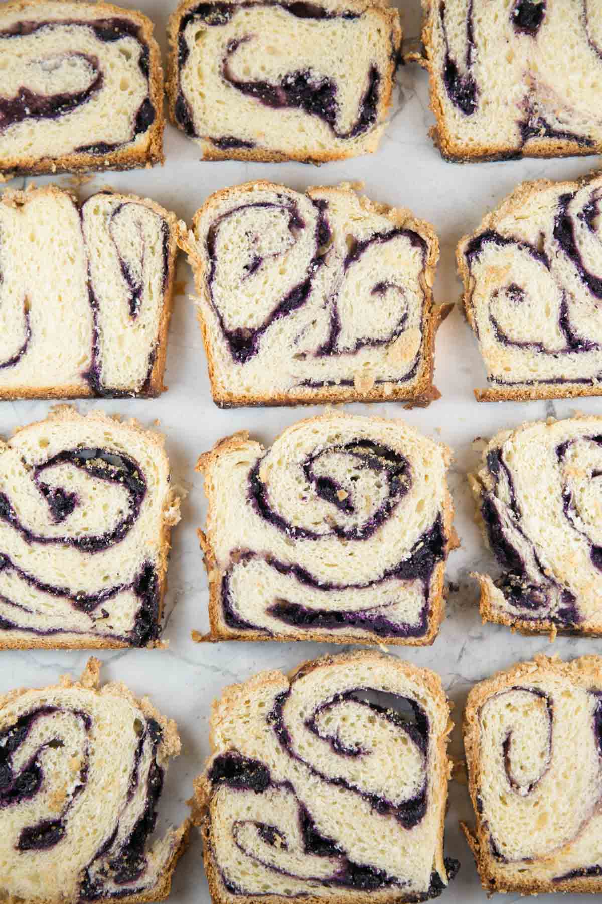 overhead view of slices of blueberry babka showing the purple fruit swirl running through each slice